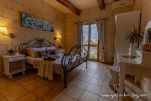 a bedroom with a bed and a bathroom with a window at Hibiscus in Xagħra +20 photos
