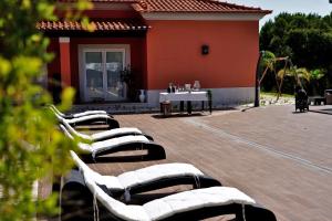 a group of lounge chairs and a table in front of a house at Monte d'Alto in Santo Estêvão