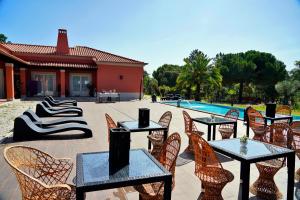 a patio with tables and chairs next to a pool at Monte d'Alto in Santo Estêvão
