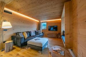 een woonkamer met een bank en een tv bij Besseghini Apartments in Livigno