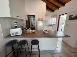 een keuken met 2 barkrukken en een aanrecht bij SeaSalt Rest in Plettenbergbaai