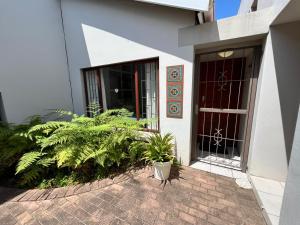 een entree van een gebouw met een deur en planten bij SeaSalt Rest in Plettenbergbaai