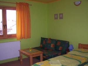 a bedroom with a couch and a bed and a table at Penzión Šindléry 533 in Partizánska ľupča