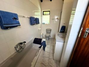 een witte badkamer met een toilet en een wastafel bij SeaSalt Rest in Plettenbergbaai +31 foto's