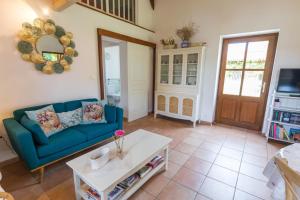 a living room with a blue couch and a table at Gite du platane in Bélis