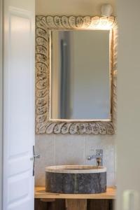 a bathroom with a stone sink and a mirror at Gite du platane in Bélis +30 photos