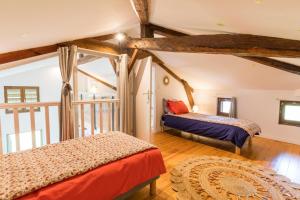 two beds in a room with wooden beams at Gite du platane in Bélis