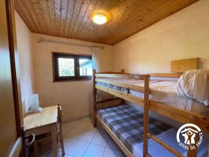 une chambre avec deux lits superposés et un bureau dans l'établissement Le gîte du Puech de Fons, à Le Cayrol