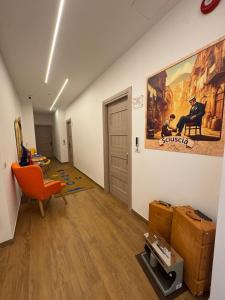 ein Wohnzimmer mit einem orangenen Stuhl und einem Gemälde an der Wand in der Unterkunft Yoyo House Luxury Napoli in Neapel