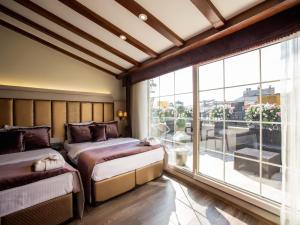 a bedroom with two beds and a large window at Bonne Sante Hotel in Istanbul