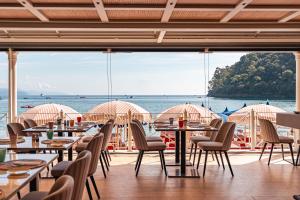 een restaurant met tafels en stoelen en uitzicht op het water bij Eight Hotel Paraggi in Santa Margherita Ligure