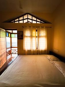 a large bed in a room with a window at SeaCret by Dormer Stay in Kozhikode