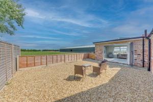 a brick house with two chairs and a table at Luxury Cottage, Dog Friendly, Stunning Views, Private Garden in Lincolnshire