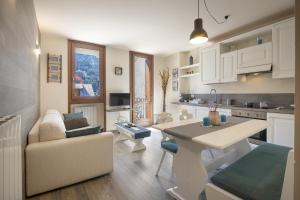 a kitchen and living room with a table and a couch at Aquilegia - AffittiPontediLegno in Ponte di Legno
