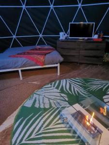 a bedroom with a bed and a glass table with candles at Lincoln Big Dome,Hot Tub,4 beds, Projector - Groups OK in Snelland