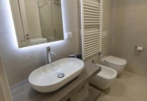 a white bathroom with a sink and a toilet at Aquilegia - AffittiPontediLegno in Ponte di Legno +4 photos