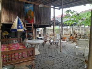 a patio with chairs and tables and an umbrella at Cactus Hostel in Chiang Mai +29 photos