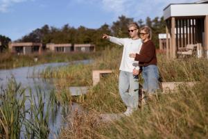 a man and a woman standing next to a body of water at Hofparken Wiltershaar in Winterswijk