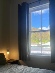 a bedroom with a window with a view of a building at Nourish Reefton & Wilsons Hotel in Reefton