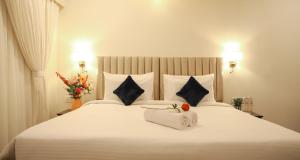 a bedroom with a large white bed with two pillows at Ello Hotels in Bengaluru