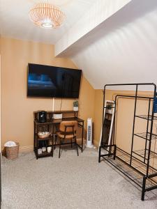 a room with a bed and a desk and a tv at The Red Lion Inn in Rothwell