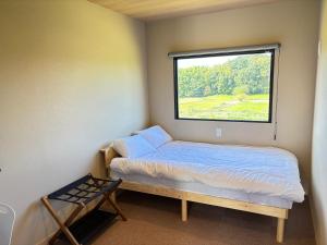 a small bedroom with a bed and a window at NikkaHotel東郷店 in Togo