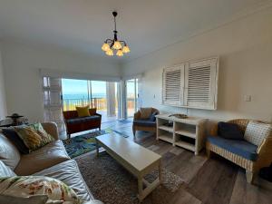 a living room with a couch and a table at Brenton-On-C-View in Brenton-on-Sea