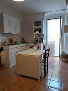 カルロフォルテにあるMy Octopus Houseの白いキャビネットとテーブルと椅子のあるキッチン