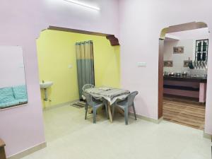 a dining room with a table and chairs at Miracle Stay in Madurai +2 photos