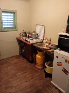 a messy kitchen with a stove and a refrigerator at Școala Zamolxiană in Predeal