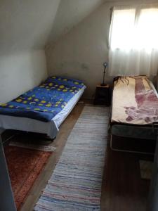 a small room with two beds and a window at Școala Zamolxiană in Predeal
