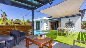 a backyard with a pool and a table and a house at Domaine Simini - Villas et Chalet entre mer et montagne in Sainte-Rose