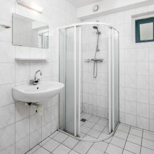 a white bathroom with a shower and a sink at Zandduin Villa met Sauna | 10 personen in Hooghalen