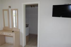 a room with a flat screen tv on a wall at Rachoni Resort in Skala Rachoniou