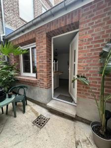a brick building with a white door and a patio at Studette Peronne Centre in Péronne