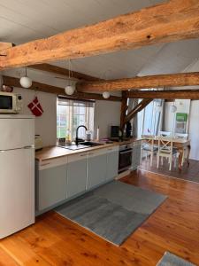 eine Küche mit einem weißen Kühlschrank und einem Tisch in der Unterkunft Ferienhof Faebrogaard in Skærbæk