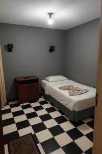 Un dormitorio con una cama y un suelo de cuadros. en Venus Downtown Hotel, en El Cairo