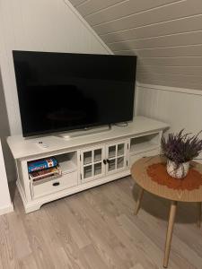 a white entertainment center with a flat screen tv on top at Lofoten - Spacious Room in Vestvågøya