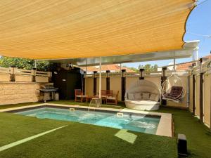 a patio umbrella over a swimming pool in a yard at Villa Arviv in Ramat Yaẖanan