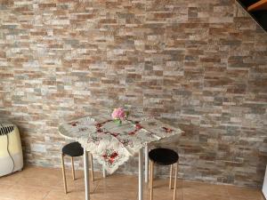 a table with a table cloth on it in a room with a brick wall at Vista Clara in Ponta do Sol