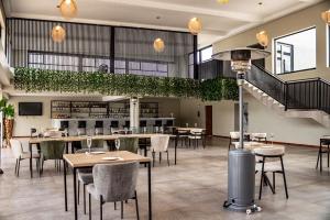 a restaurant with tables and chairs and a staircase at The Legacy Hotel and Spa in Tzaneen
