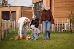 a group of people playing with a dog in the yard at Hofparken Wiltershaar in Winterswijk