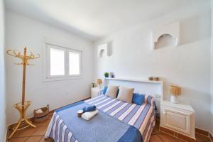 ein weißes Schlafzimmer mit einem Bett und einem Fenster in der Unterkunft Mirador de la Isleta in La Isleta del Moro