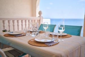 einen Tisch mit Tellern und Gläsern Wein darauf in der Unterkunft Mirador de la Isleta in La Isleta del Moro