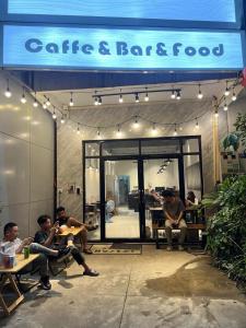 a group of people sitting in front of a store at The Witcher Hostel in Vientiane