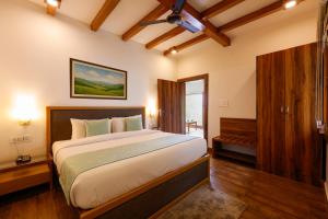 a bedroom with a large bed and a window at WelcomHeritage Arka Resort & Spa, Rishikesh in Bijni