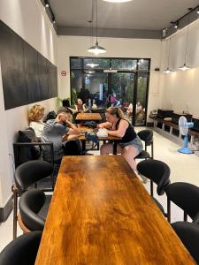 a group of people sitting at tables in a room at The Witcher Hostel in Vientiane