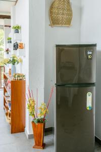 a stainless steel refrigerator in a kitchen with flowers at Garden Villa Talalla in Talalla