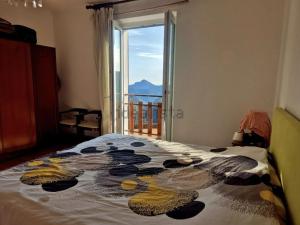 een slaapkamer met een bed met een groot raam bij Casa Mare & Monti in Caprauna
