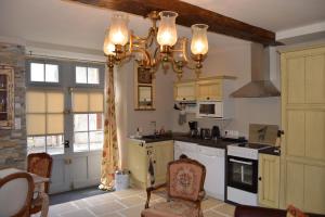 a kitchen with a chandelier hanging from the ceiling at Haut du Blanc in Le Blanc